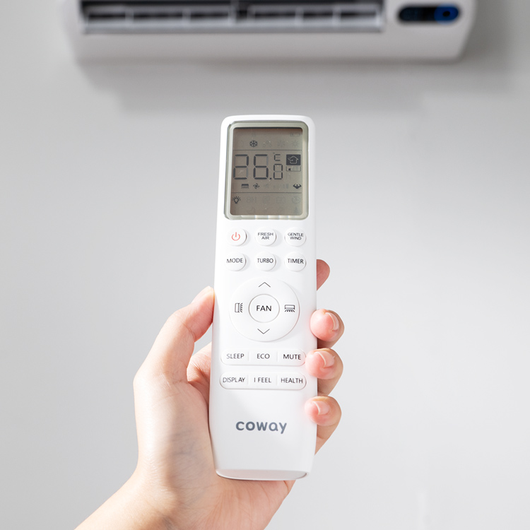 Remote control Coway air conditioner dipegang di depan unit aircond